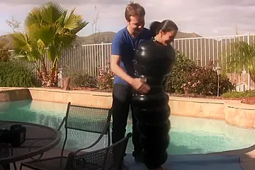 Julia in an inflatable latex cocoon in pool - porn video
